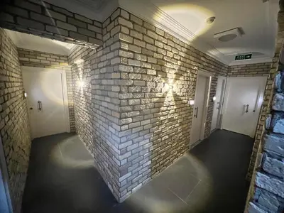 a room with a brick wall and two white doors at Karaca Suite in Tuzla