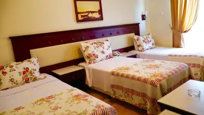 a hotel room with two beds and a table at Kumburgaz Blue World Hotel in Buyukcekmece