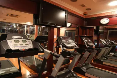 a gym with several tread machines and a television at Kumburgaz Blue World Hotel in Buyukcekmece