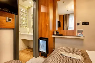 a small room with a bed and a sink and a mirror at Santra Hotel in Istanbul