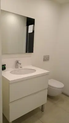 a white bathroom with a sink and a toilet at Prime Istanbul Residences in Istanbul