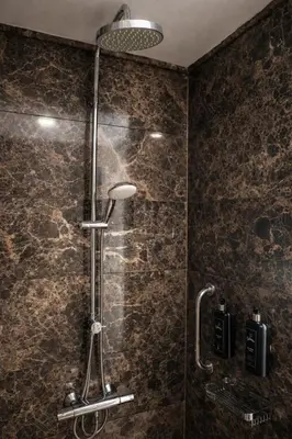 a shower in a bathroom with a stone wall at Prime Istanbul Residences in Istanbul