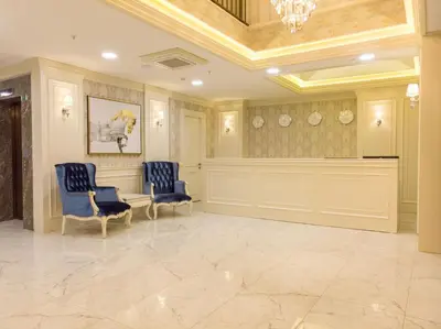 a waiting room with two blue chairs and a chandelier at Bursa Ulupark Hotel in Bursa