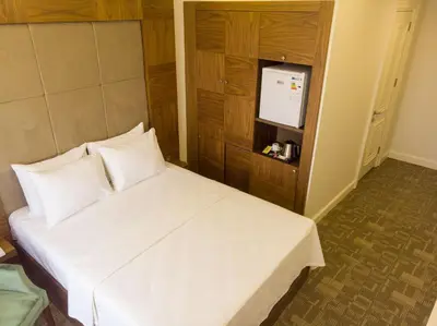 a bedroom with a white bed and a television at Bursa Ulupark Hotel in Bursa