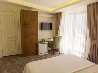 a hotel room with a bed and a desk and a window at Bursa Ulupark Hotel in Bursa