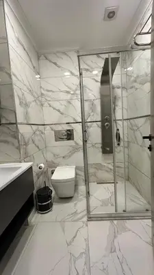 a marble bathroom with a shower and a toilet at La Vie Suite Hotel in Istanbul