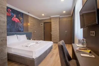 a bedroom with a large white bed and a desk at La Vie Suite Hotel in Istanbul