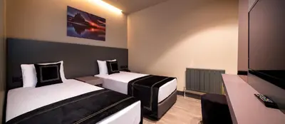 a hotel room with two beds and a television at MENALO HOTEL PREMIUM ISTANBUL AIRPORT in Istanbul