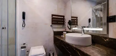 a bathroom with a sink and a toilet and a phone at MENALO HOTEL PREMIUM ISTANBUL AIRPORT in Istanbul