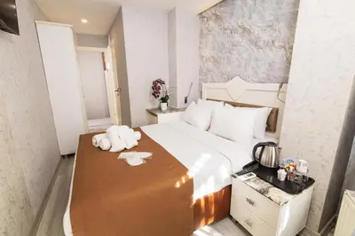 a bedroom with a large bed with a wooden table at Kupa HOTEL in Istanbul