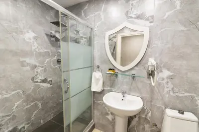 a bathroom with a sink and a mirror and a toilet at Kupa HOTEL in Istanbul