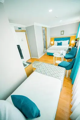 a room with a bed and two blue chairs at Acacia Mansion Hotel in Istanbul