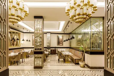 a restaurant with tables and chairs and chandeliers at Ramada by Wyndham Istanbul Golden Horn in Istanbul