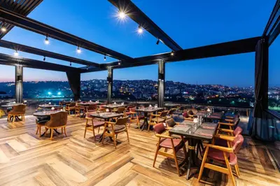 a restaurant with tables and chairs and a view at Ramada by Wyndham Istanbul Golden Horn in Istanbul