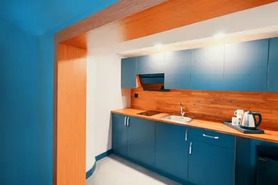 a kitchen with blue cabinets and a sink at Roof 264 Hotel & Suites in Sakarya