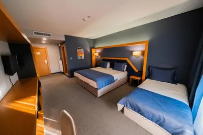 a small room with two beds and a television at Roof 264 Hotel & Suites in Sakarya
