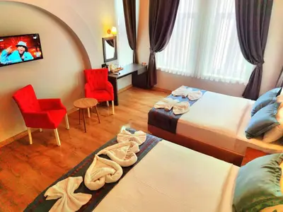 a hotel room with two beds and a table and chairs at The Independent Hotel Taksim in Istanbul