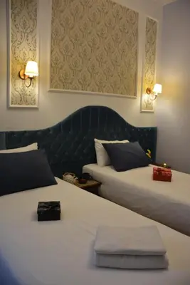 a hotel room with two beds and a headboard at The Independent Hotel Taksim in Istanbul