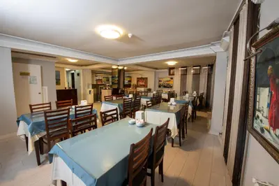 a dining room with blue tables and wooden chairs at GRAND VATAN HOTEL in Istanbul
