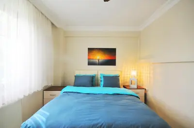 a bedroom with a blue bed and a painting on the wall at Apart Point in Istanbul