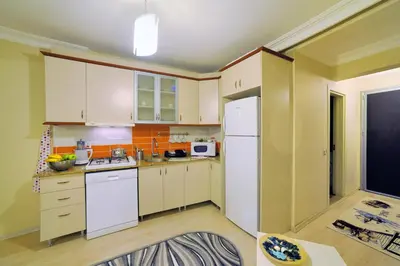 a kitchen with white cabinets and a white refrigerator at Apart Point in Istanbul