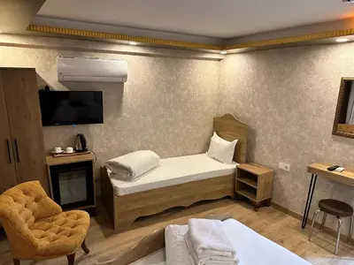 a bedroom with a bed and a tv and a chair at Golden Sail Hotel Old City in Istanbul