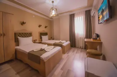 a hotel room with two beds and a tv at Hotel Orkide in Istanbul