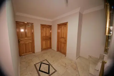an empty room with wooden doors and a tile floor at Hotel Orkide in Istanbul