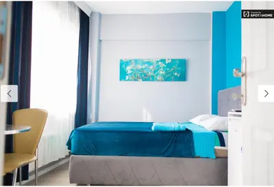 a bedroom with a blue bed and a chair at Blue Apartment in Istanbul