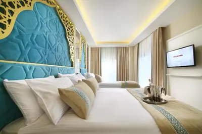 a bedroom with a large bed with a blue wall at Great Fortune Design Hotel & Spa in Istanbul
