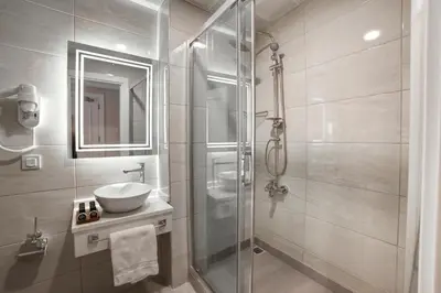 a bathroom with a sink and a glass shower at Great Fortune Design Hotel & Spa in Istanbul
