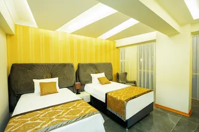 two beds in a room with yellow walls at Continent Luxury Suites Sakarya in Sakarya