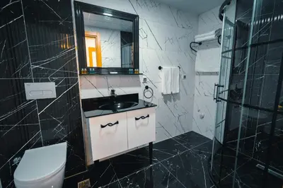 a bathroom with a sink and a toilet and a mirror at Continent Luxury Suites Sakarya in Sakarya
