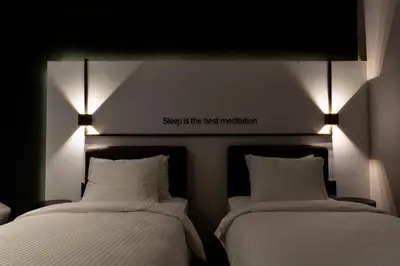 two beds in a room with lights on the wall at Hotel Bonvie in Sakarya