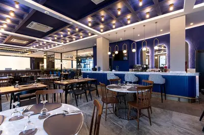 a restaurant with tables and chairs and a bar at Hotel Bonvie in Sakarya