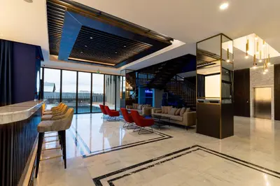 a kitchen and living room with red chairs at Hotel Bonvie in Sakarya