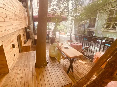 a woman sitting at a table on a wooden deck at Siesta Premium Hotel in Istanbul