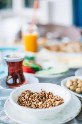 a bowl of nuts on a table with plates of food at Büyükada Loc'ada in Adalar
