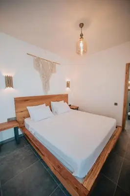 a bedroom with a large bed with white sheets at Büyükada Loc'ada in Adalar