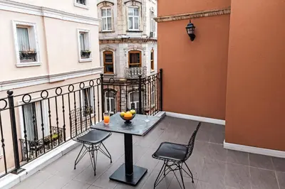 a table and chairs on the balcony of a building at Galata Door Hotel in Istanbul