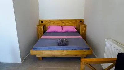 a bed with two pink pillows and a pair of shoes at Sahil Kamp İstanbul Hotel in Sile
