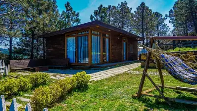 a log cabin with a hammock in front of it at Sahil Kamp İstanbul Hotel in Sile