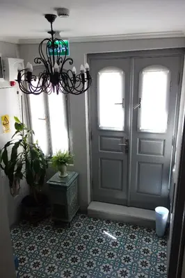 a hallway with a door and a chandelier at Tilas - Rooms in 19th Century Wooden Townhouse,Kadikoy in Istanbul