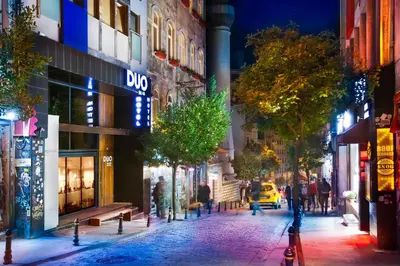 a city street at night with people walking down the street at Duo Galata Hotel in Istanbul