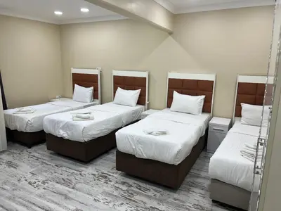a room with three beds with white sheets at King Istanbul Hotel in Istanbul