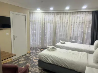 a hotel room with two beds and a window at King Istanbul Hotel in Istanbul