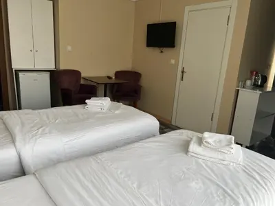two white beds in a room with a table and chairs at King Istanbul Hotel in Istanbul