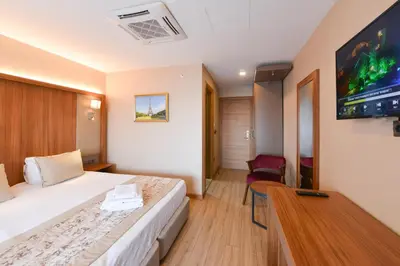a hotel room with a bed and a flat screen tv at İstport Hotels in Arnavutköy