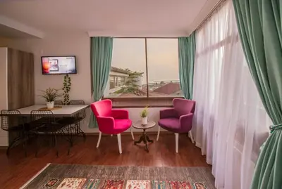 a room with pink chairs and a table and a window at Duru Istanbul Apart in Istanbul