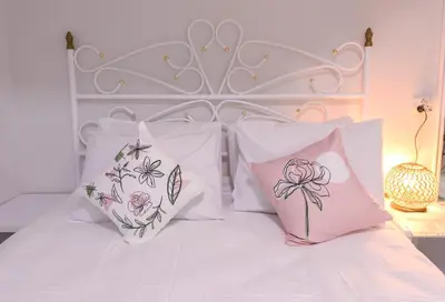 a bed with four pillows with flowers on it at Duru Istanbul Apart in Istanbul
